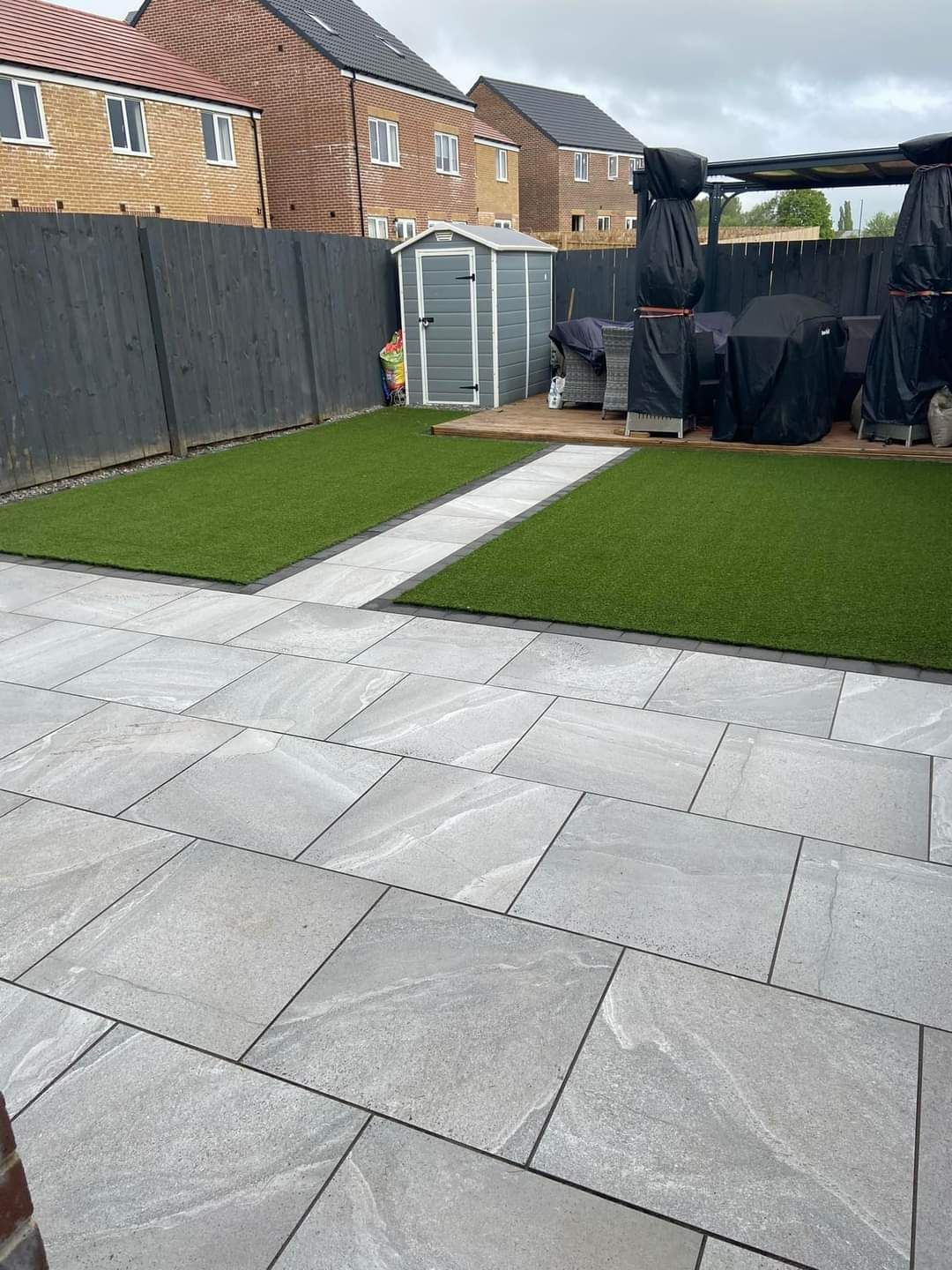 Grey porcelain patio with artificial lawn and stepping strip