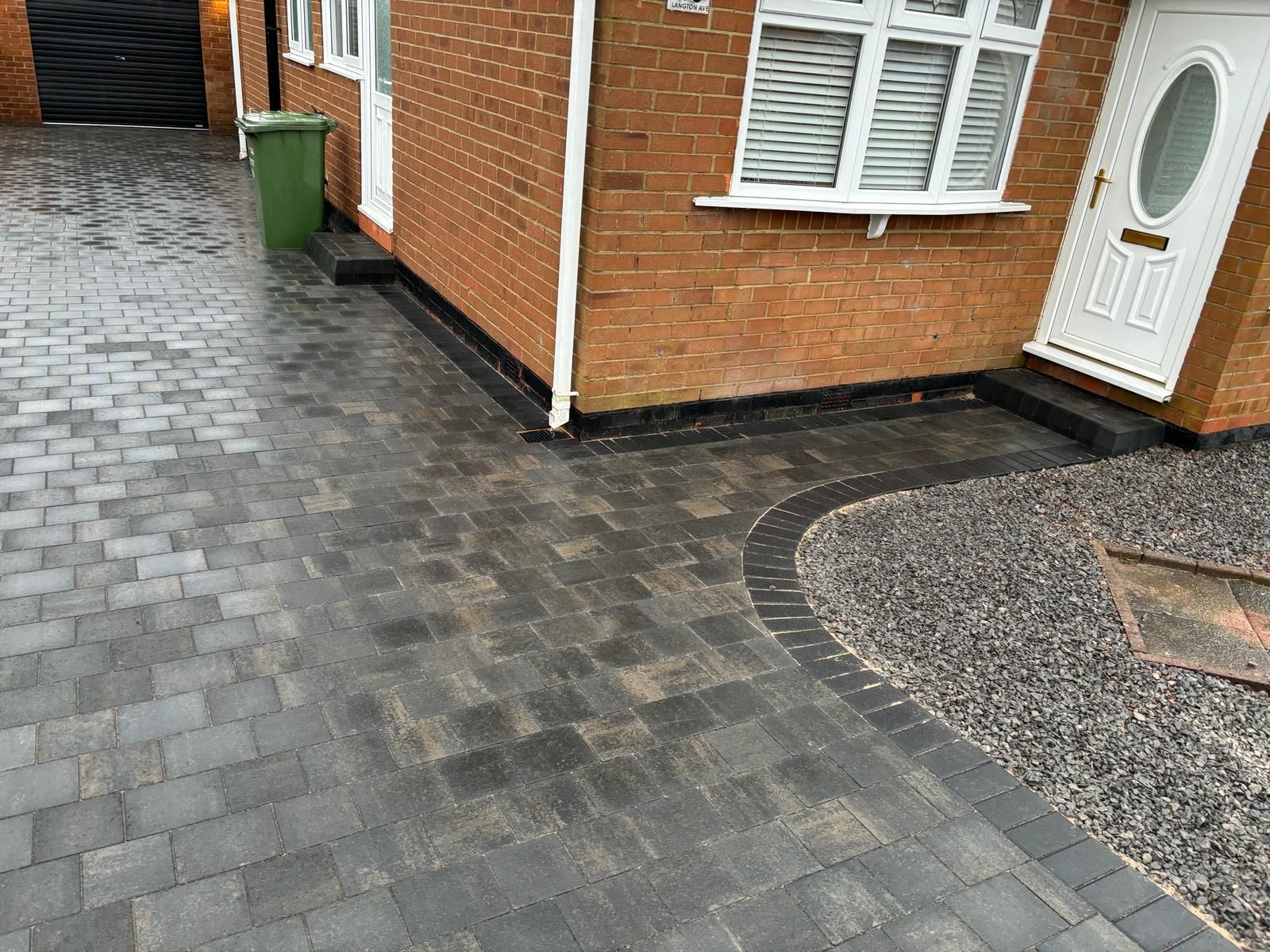 Charcoal block paved driveway and path with a curved soldier course