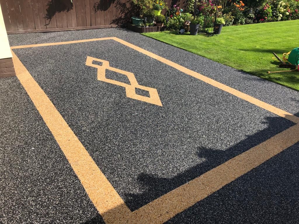 Charcoal resin bound surface with a gold border and diamond inlay detail